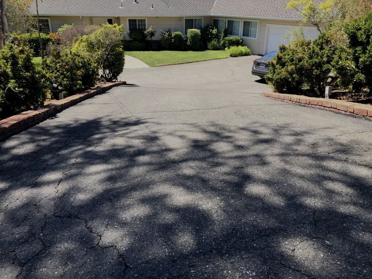 Before: cracked, faded asphalt driveway